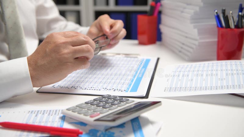 Om de afaceri care lucrează și calculează lecturi și scrie rapoarte. închidere tabel angajat birou. conț de contabilitate financia stock video footage