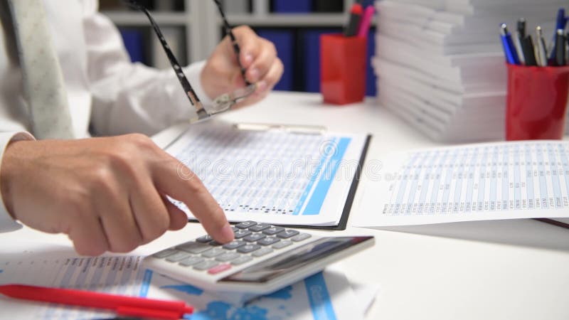 Om de afaceri care lucrează și calculează lecturi și scrie rapoarte. închidere tabel angajat birou. conț de contabilitate financia stock video