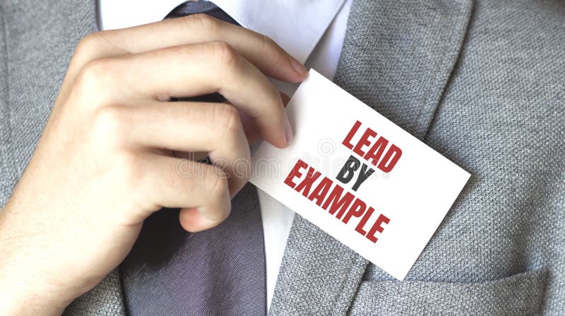 Om de afaceri care pune un card cu text plumb de exemplu în buzunar royalty free stock photos