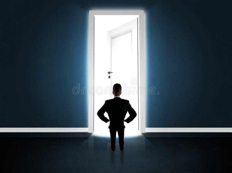 Om de afaceri care se uită la o ușă mare și strălucitoare deschisă stock photos