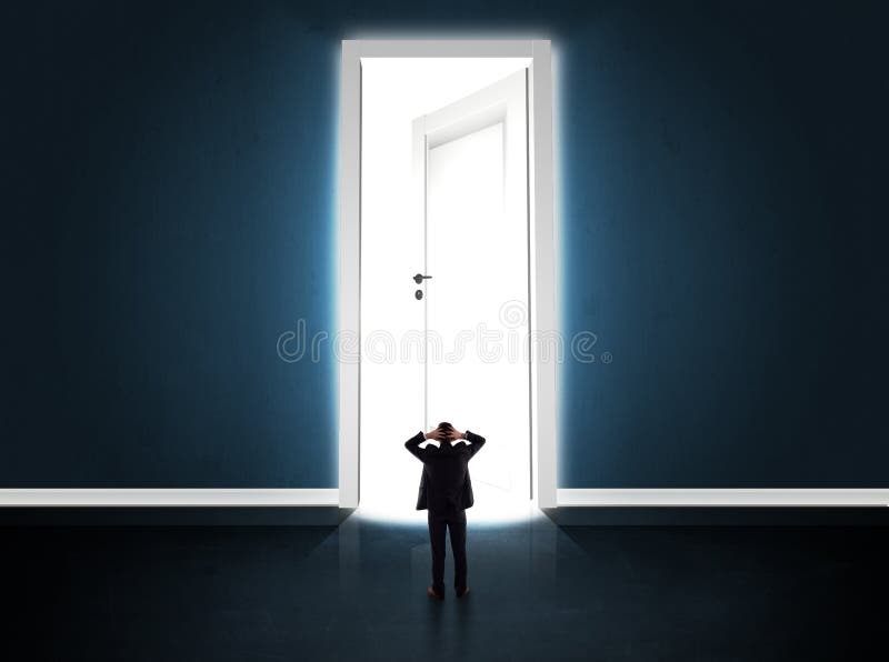 Om de afaceri care se uită la o ușă mare și strălucitoare deschisă royalty free stock photography