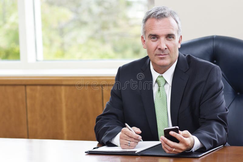 Om de afaceri matur care lucrează în biroul său stock image