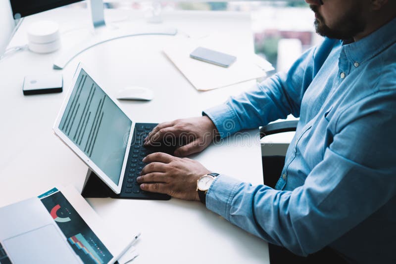 Om de afaceri nerecunoscut care lucrează la tablete în birou stock image