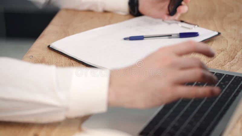 Om de afaceri închis a scris în notebook-ul notepad cu laptop pe birou. document de raportare stock video