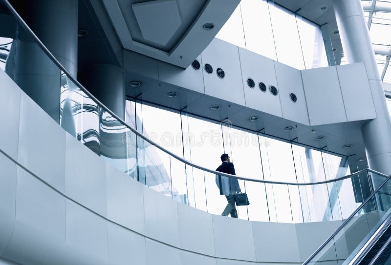 Om de afaceri îndepărtat care merge într-o clădire de birouri modernă stock photos