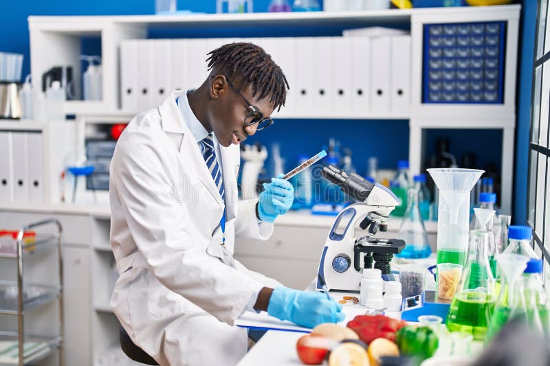 Om de știință american din Africa care scrie un raport de testare a tubului în laborator royalty free stock images