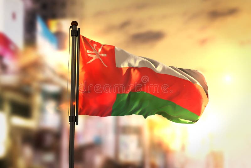 Oman Flag Against City Blurred Background At Sunrise Backlight stock photos