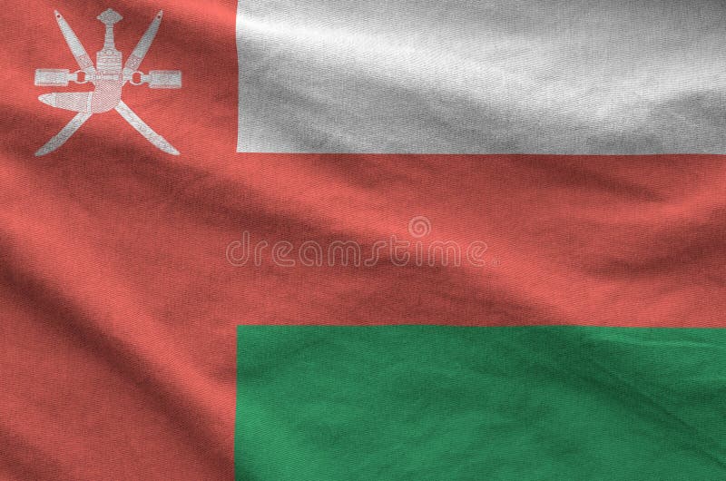 Oman flag depicted on folded wavy fabric of old cloth stock photo