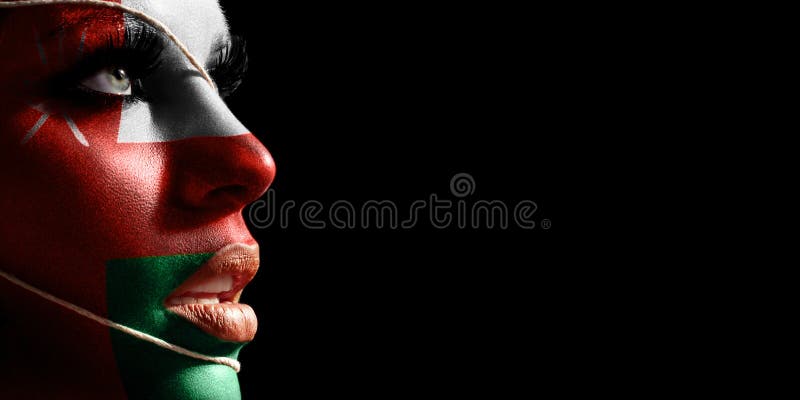 Oman flag painted on a face of a young woman national flag stock photos.