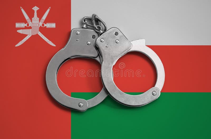 Oman flag and police handcuffs. The concept of observance of the law in the country and protection from crime stock photography