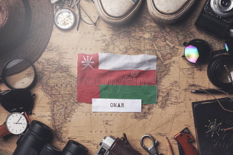 Oman Flag Between Traveler`s Accessories on Old Vintage Map. Overhead Shot royalty free stock photography