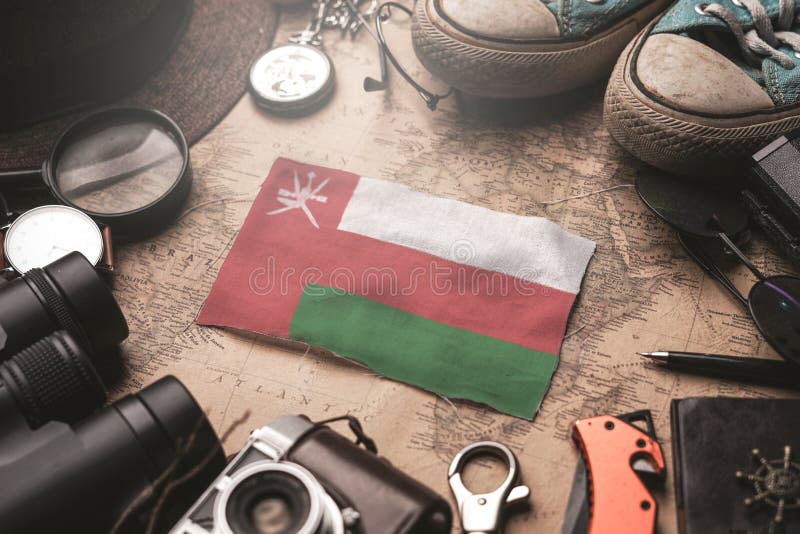 Oman Flag Between Traveler`s Accessories on Old Vintage Map. Tourist Destination Concept stock photos