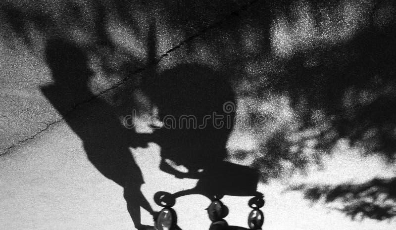 Ombra di una donna che spinge un carrello del bambino fotografia stock libera da diritti Ombra di una donna che spinge un carrello del bambino fotografia stock libera da diritti