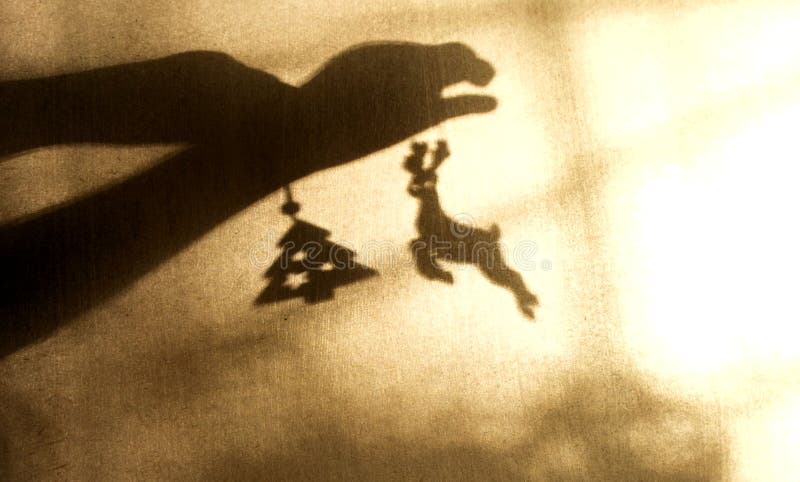 Ombre floue des mains d'enfant sur le mur. enfant jouant avec des jouets de noël. jeu avec lumière et ombre