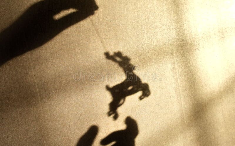 Ombre floue des mains d'enfant sur le mur. enfant jouant avec un jouet de noël. jeu avec lumière et ombre