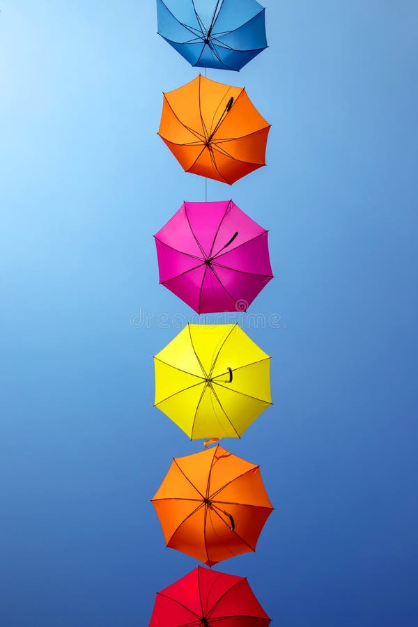 Ombrelli colorati contro il cielo azzurro immagine stock