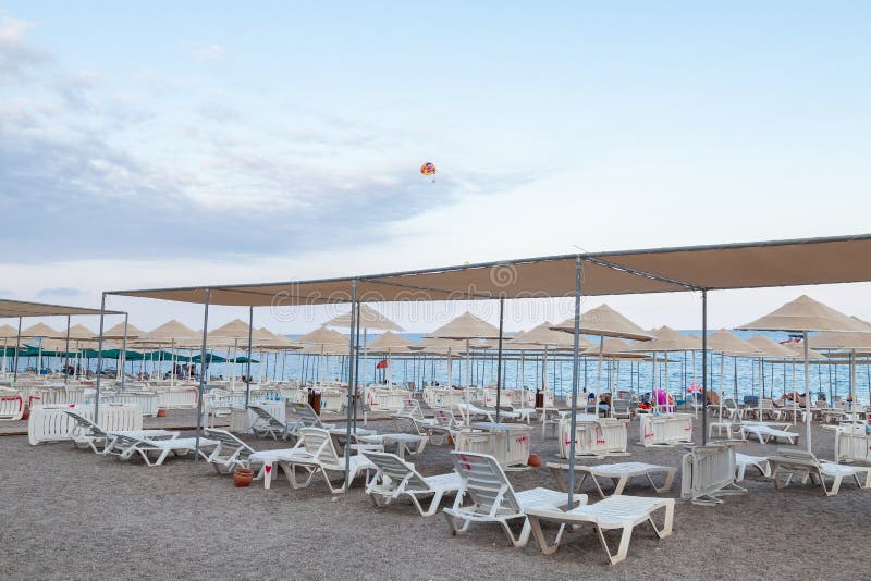 Ombrelli da spiaggia e letti solari sulla spiaggia di tacchino sandy. pioggia di ombrelli bianchi e gialli senza persone a causa d fotografie stock