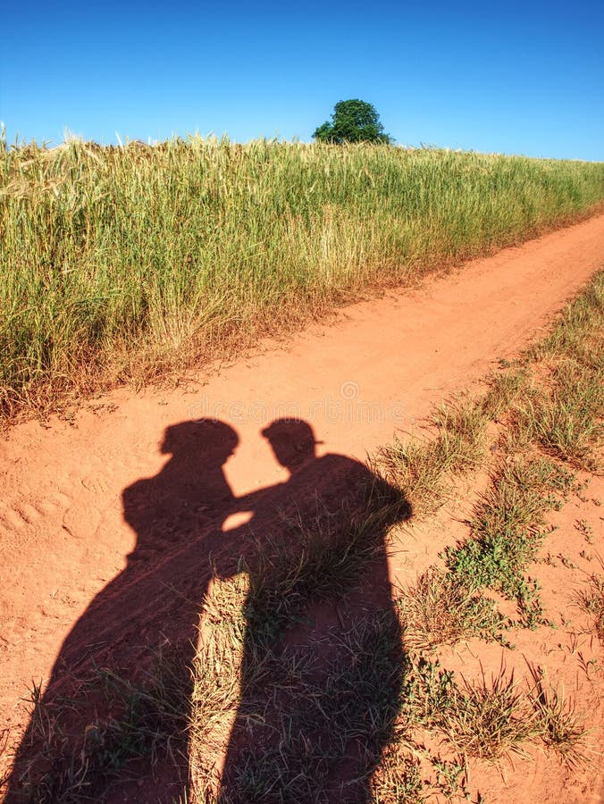 Ombres de personnes sur la vieille route poussiéreuse avec le sol rouge ferrique ombres photo libre de droits