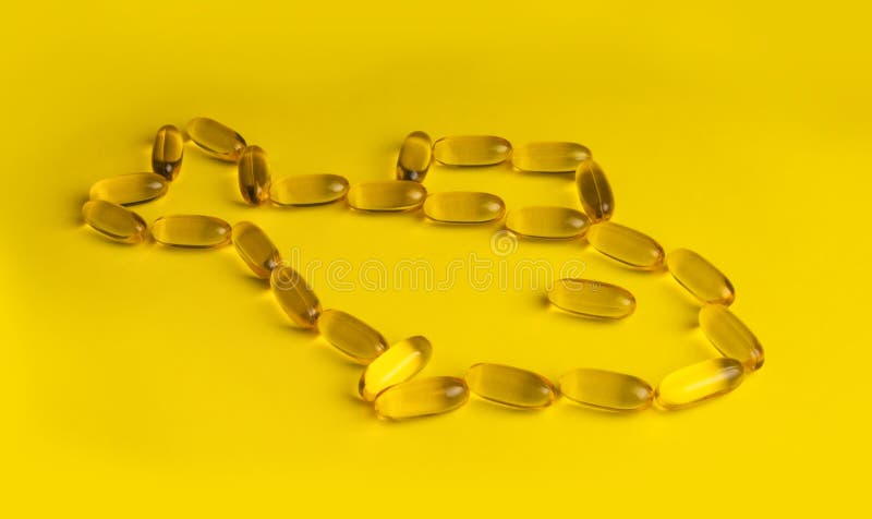 omega 3 gel capsules on yellow background