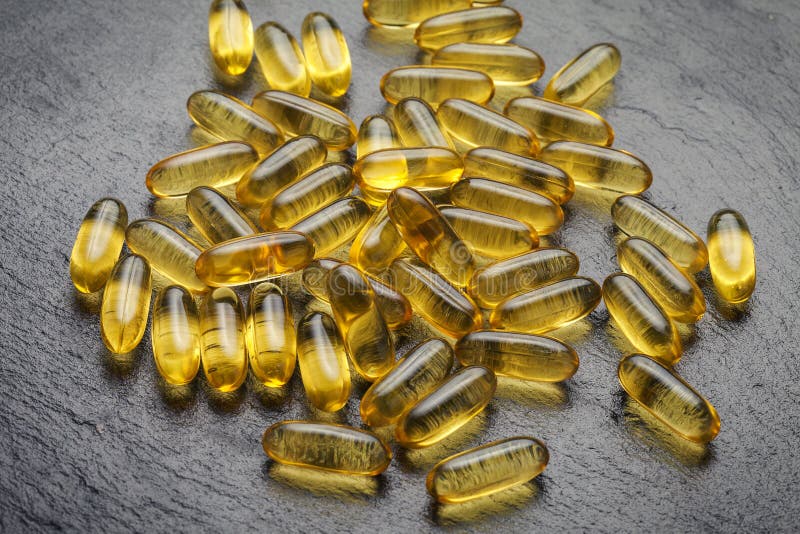 Omega 3. Transparent fish oil capsules on a black background