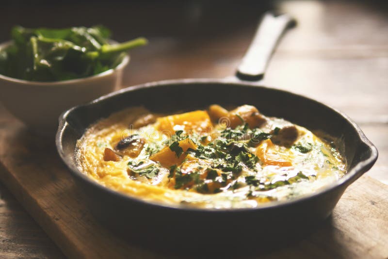 Omelette with Vegetables in Old Vintage Iron Frying Pan on Wooden Table. Autumn Vegetarian Breakfast. royalty free stock photography Omelette with Vegetables in Old Vintage Iron Frying Pan on Wooden Table. Autumn Vegetarian Breakfast. royalty free stock photography