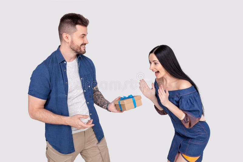 OMG Foto för profilsidosikt av den förvånade nätta damen som får giftboxgratulationer från vinkande händer för skäggig stilig äls royaltyfri fotografi OMG Foto för profilsidosikt av den förvånade nätta damen som får giftboxgratulationer från vinkande händer för skäggig stilig äls royaltyfri fotografi