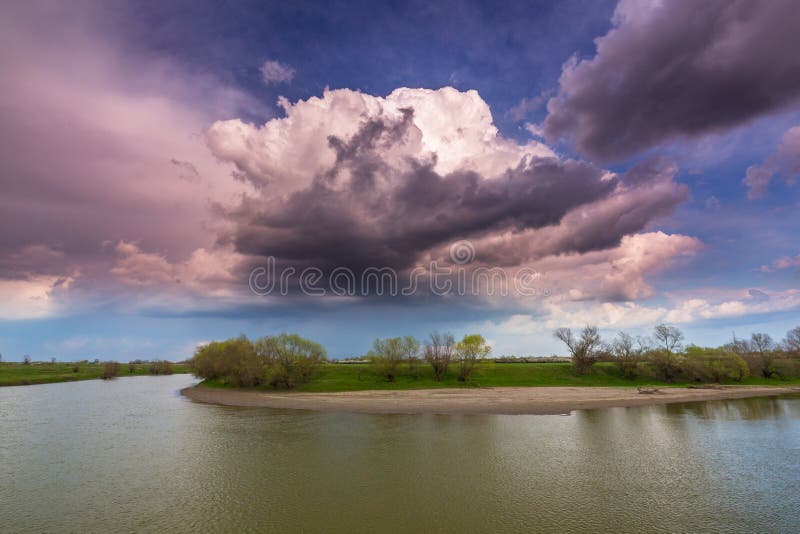 Ominous stormy sky over natural flooded river