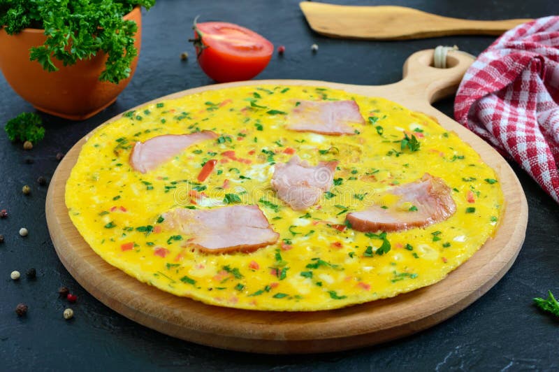 Omlet z baleronem, ser, zielenieje na drewnianej desce na czarnym tle Fritata - wy?mienicie, ?niadanie obraz stock Omlet z baleronem, ser, zielenieje na drewnianej desce na czarnym tle Fritata - wy?mienicie, ?niadanie obraz stock
