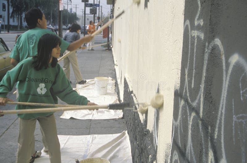 Several community members participate in covering graffiti for Clean & Green Day, an urban cleanup pro+B302ject in East Los Angeles, CA. Several community members participate in covering graffiti for Clean & Green Day, an urban cleanup pro+B302ject in East Los Angeles, CA