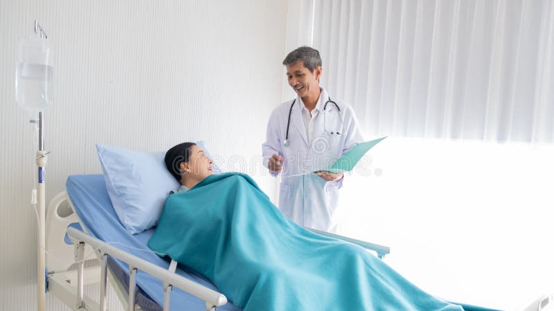 Omtalad doktor sjukdomen av den kvinnliga patienten i sjukhuset royaltyfri bild Omtalad doktor sjukdomen av den kvinnliga patienten i sjukhuset royaltyfri bild