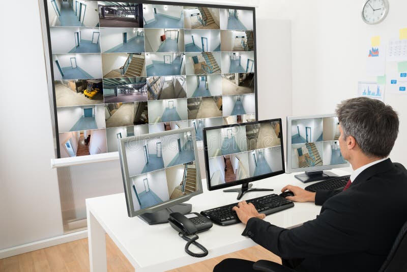 Omul din camera de control se uită la imaginile camerelor stock image