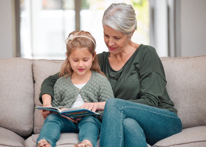 She gets her love for books from me. a grandmother and granddaughter bonding on the sofa while using a digital tablet. She gets her love for books from me. a grandmother and granddaughter bonding on the sofa while using a digital tablet