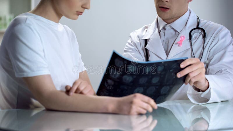 Oncologist consultation, doctor shows patient mammogram, breast cancer awareness