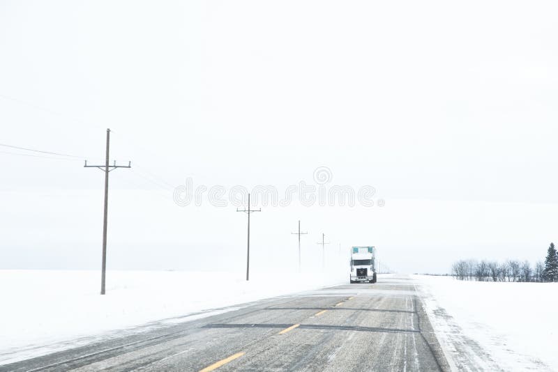 An oncoming semi truck and trailer in a winter landscape
