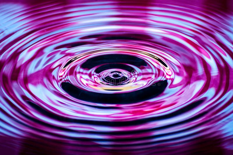 Waves of water caused by the falling droplets with psychedelic lighting. Waves of water caused by the falling droplets with psychedelic lighting.