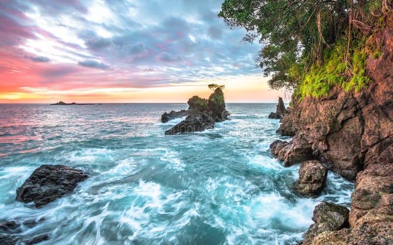 Ondas de oceano e penhascos litorais no por do sol em Costa Rica