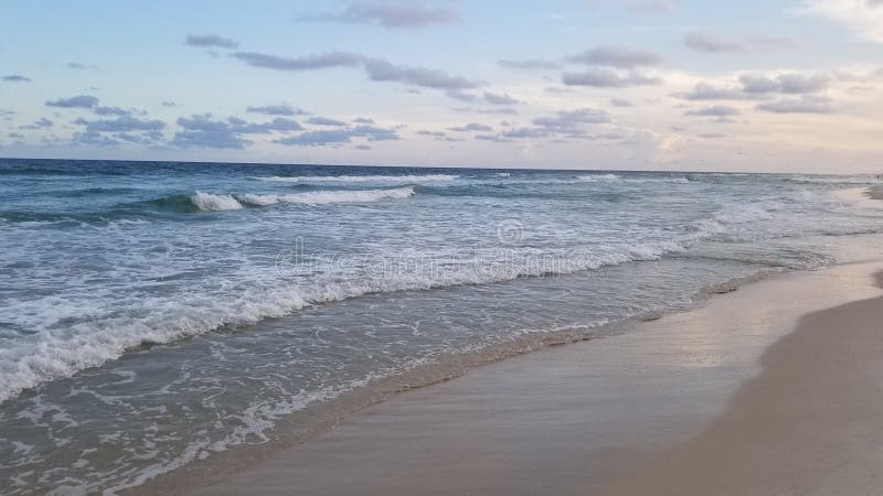 Ondas de oceano em uma praia sob o por do sol do verão fotografia de stock Ondas de oceano em uma praia sob o por do sol do verão fotografia de stock