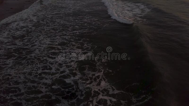 Ondas do mar que espirram no Sandy Beach quando opinião do zangão do nascer do sol da manhã Ondas de água aéreas da paisagem no q