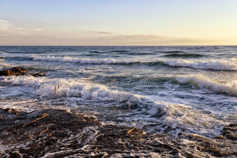 Ondas no mar pelos corrimões da natação fotos de stock