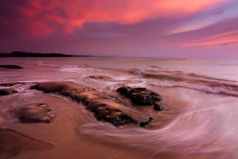 Onde e tramonto ad una spiaggia fotografia stock libera da diritti Onde e tramonto ad una spiaggia fotografia stock libera da diritti
