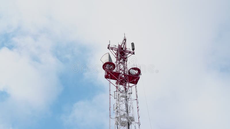 Onderaanzicht van een televisie- en radiozendantenne tegen de achtergrond van een blauwe hemel en bewegende wolken. de