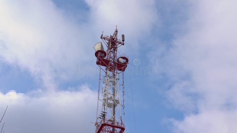 Onderaanzicht van een televisie- en radiozendantenne tegen de achtergrond van een blauwe hemel en bewegende wolken. de