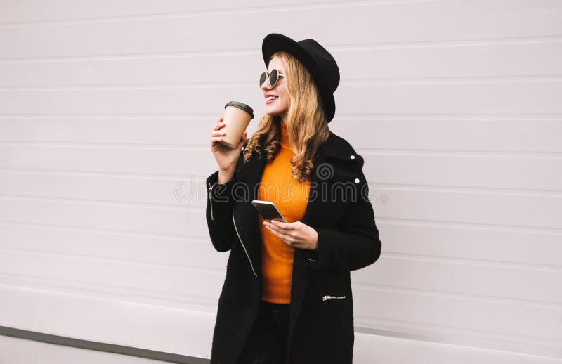 Onderbrekingstijd! Houdt de manier glimlachende vrouw die van koffie genieten smartphone in stad op grijs stock foto's Onderbrekingstijd! Houdt de manier glimlachende vrouw die van koffie genieten smartphone in stad op grijs stock foto's