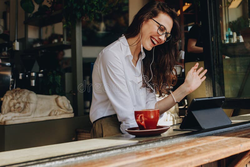 Onderneemster die bij koffie een videogesprek maken royalty-vrije stock afbeelding Onderneemster die bij koffie een videogesprek maken royalty-vrije stock afbeelding
