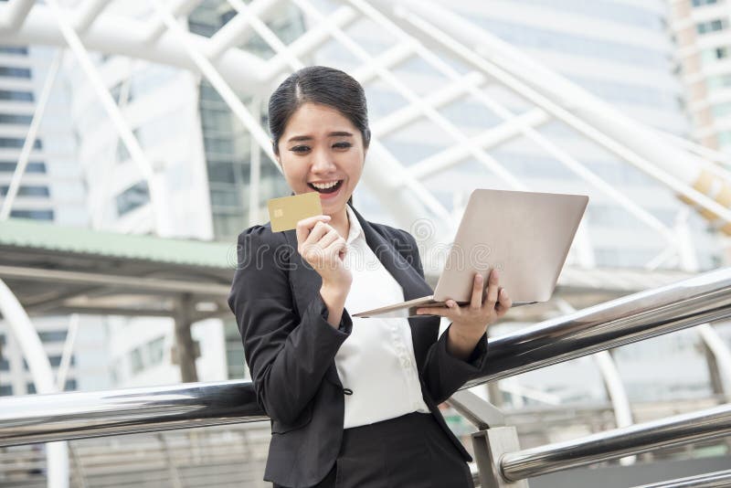 Onderneemster die computer en creditcard voor Internet-bank gebruiken stock fotografie Onderneemster die computer en creditcard voor Internet-bank gebruiken stock fotografie