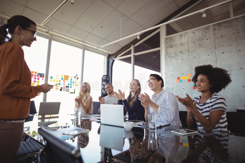 Businesswoman giving presentation with colleagues in meeting room. Businesswoman giving presentation with colleagues in meeting room