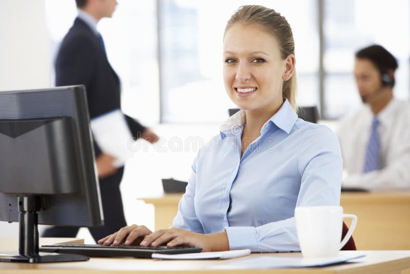 Onderneemster Working At Desk in Bezig Bureau stock foto's Onderneemster Working At Desk in Bezig Bureau stock foto's
