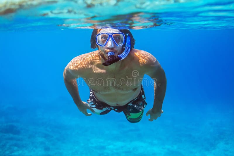 Onderwaterspruit van een jonge mens die in een tropische overzees snorkelen royalty-vrije stock foto Onderwaterspruit van een jonge mens die in een tropische overzees snorkelen royalty-vrije stock foto