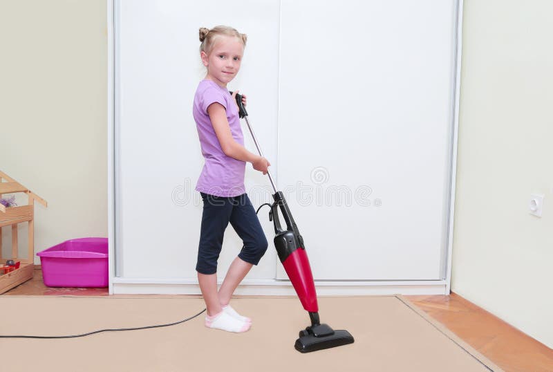 Onderwijs van kinderenconcept, het schoonmaken Jong blond meisjes schoonmakend tapijt in haar ruimte met stofzuiger royalty-vrije stock foto Onderwijs van kinderenconcept, het schoonmaken Jong blond meisjes schoonmakend tapijt in haar ruimte met stofzuiger royalty-vrije stock foto