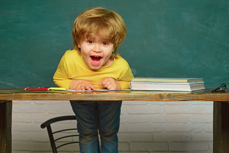 Onderwijs Vrolijk glimlachend kind bij het bord Hard examen schoolkind Gelukkige glimlachende leerlingen die bij het bureau trekk royalty-vrije stock foto's Onderwijs Vrolijk glimlachend kind bij het bord Hard examen schoolkind Gelukkige glimlachende leerlingen die bij het bureau trekk royalty-vrije stock foto's